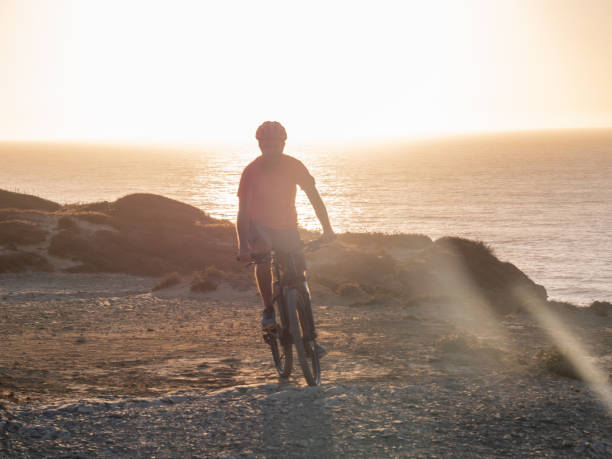 istock Mountain biker riding on the edge of a cliff at sunset 1265067394