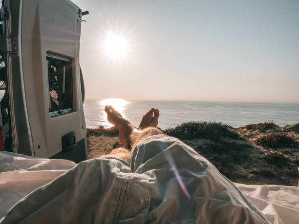 istock man lying at the back of a van looking at ocean, personal perspective 1265067499