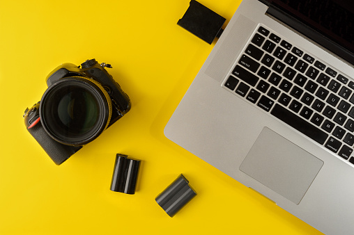 Photographer's equipment.Flat lay composition with photographer's equipment and laptop on yellow background.Photographer's workplace on a yellow background.Copy space