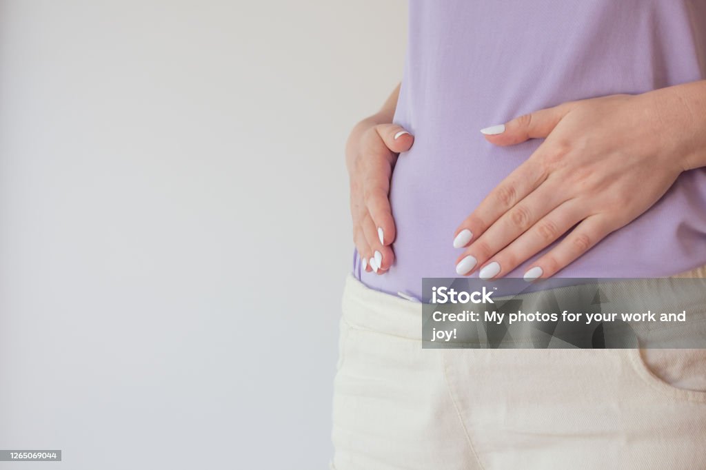 Pregnant woman in the early stages touches the belly with her hands. First and second trimester of pregnancy Pregnant woman in the early stages touches the belly with her hands. First and second trimester of pregnancy. Pregnant Stock Photo