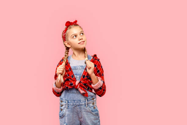 freestyle. niña en pañuelo en la cabeza con trenzas de pie aislado en el pensamiento rosa sonriendo sueño copia espacio - facial expression small empty joy fotografías e imágenes de stock