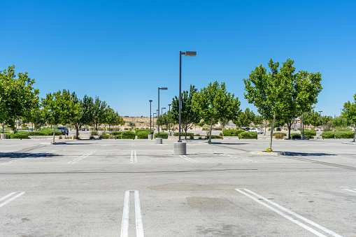 Apple Valley, CA / USA – August 8, 2020: A shopping center’s parking lot is empty due to COVID-19 closures of retail stores in Apple Valley, California.