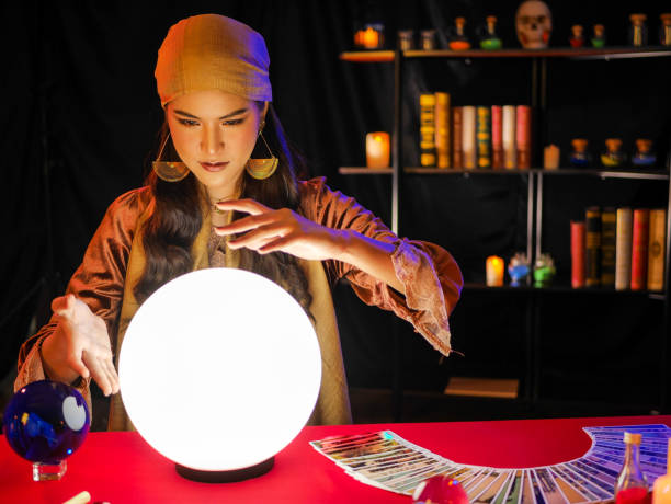 istock Asian woman fortune teller with crystal ball on red table 1265077582