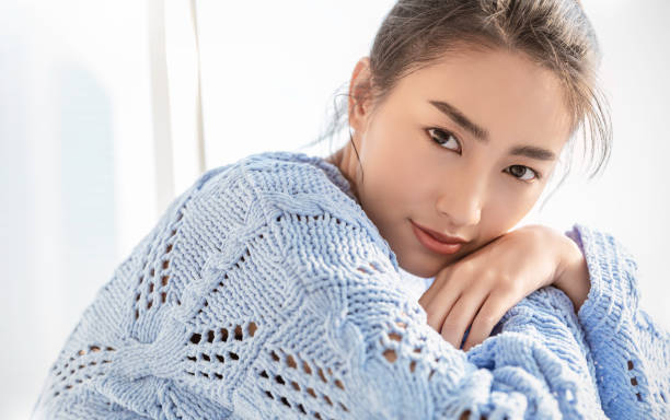 Portrait of young beautiful asian woman relax face in winter bedroom. Closeup sexy beauty fashion girl healthy makeup facial treatment perfect glow skin. Smile happy asia korean girl in blue sweater. Portrait of young beautiful asian woman relax face in winter bedroom. Closeup sexy beauty fashion girl healthy makeup facial treatment perfect glow skin. Smile happy asia korean girl in blue sweater. clear morning sky stock pictures, royalty-free photos & images