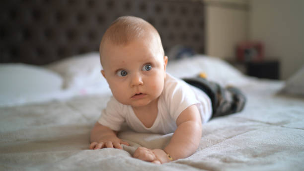 istock Cute baby playing in bed 1265078003