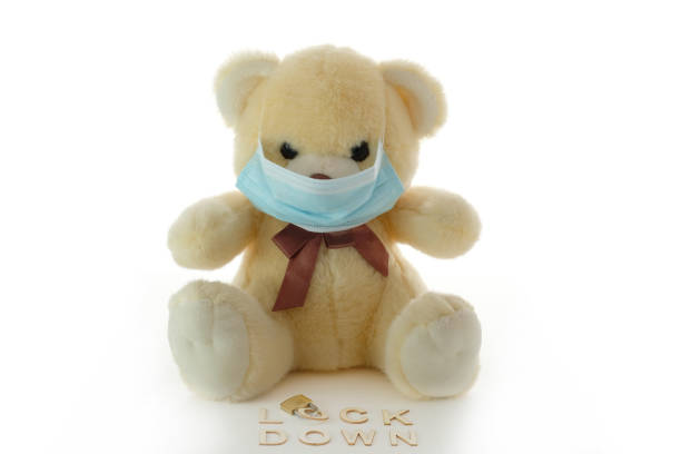 istock Plush bear with mask in front of the heading 