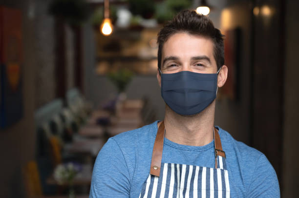istock Waiter working at a cafe wearing a facemask 1265081969