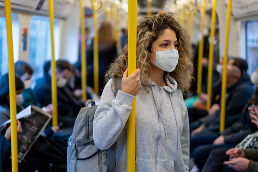 Mujer montando en el metro con una máscara facial para evitar una enfermedad infecciosa photo