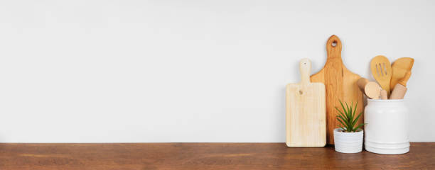 istock Kitchenware and utensils on a wood shelf. Banner with a white wall background and copy space. 1265082086