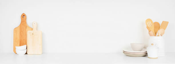istock Kitchenware and utensils on a white shelf or counter. Banner with copy space against a white wall. 1265082176