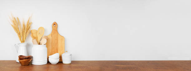 istock Kitchenware and utensils on a wood shelf or counter. Banner with a white wall background and copy space. 1265082191