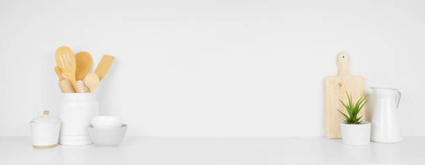 istock Kitchenware and utensils on a white shelf or counter. Banner with a white background and copy space. 1265082212