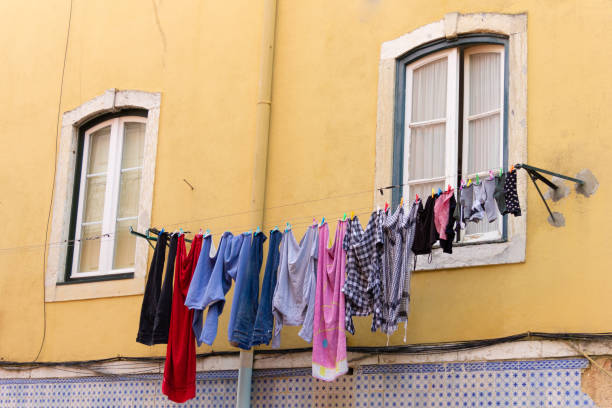 istock Colorful clothes hanging on yellow building facade 1265083269