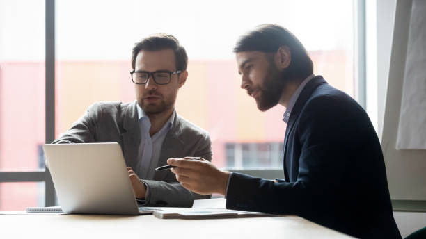 istock Male colleagues brainstorm working on laptop together 1265084530