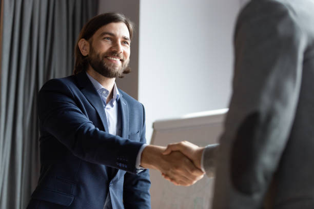 istock Smiling businessman handshake greeting with coworker at briefing 1265084533