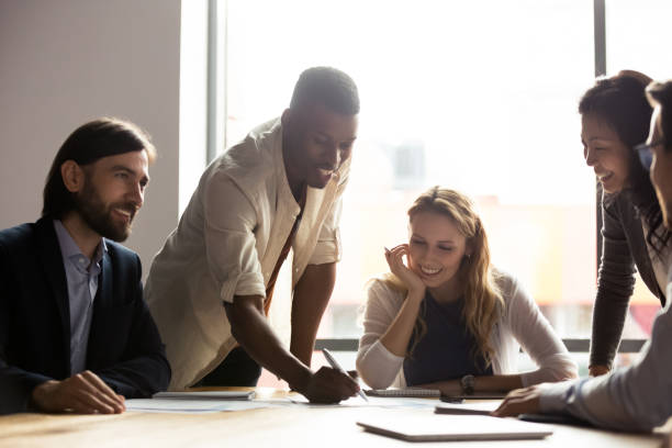 istock Smiling multiracial colleagues discuss paperwork at meeting 1265084555