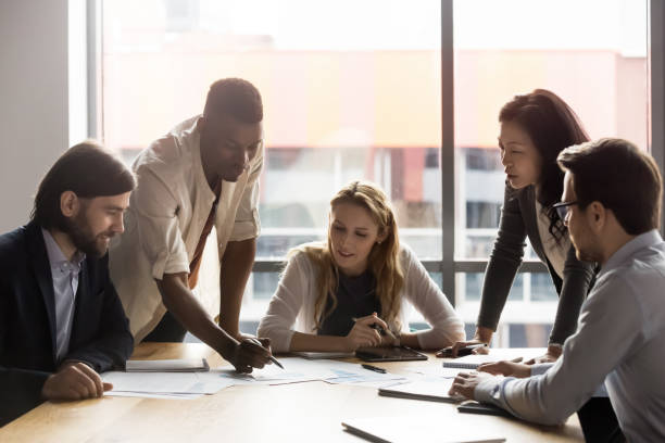 istock Multiracial colleagues discuss financial paperwork at meeting 1265084559
