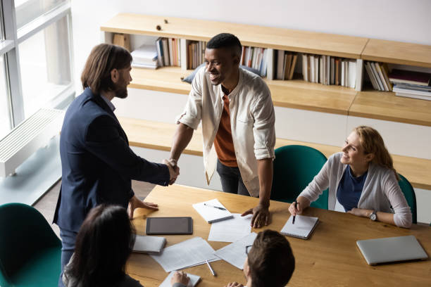 istock Smiling diverse colleagues handshake getting acquainted at meeting 1265084562