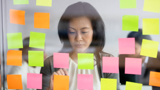 istock Pensive Asian businesswoman brainstorm develop business project on notes 1265084579