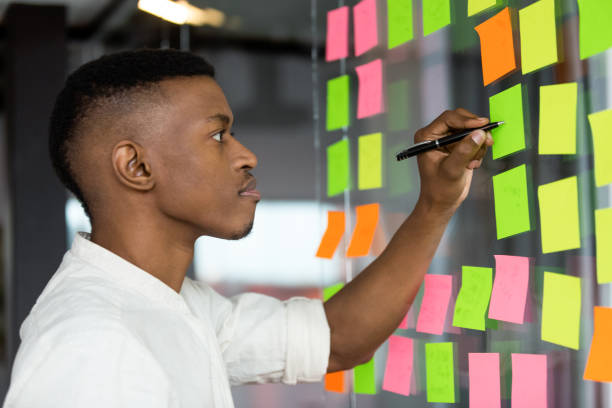istock African American male employee brainstorm writing ideas on notes 1265084581
