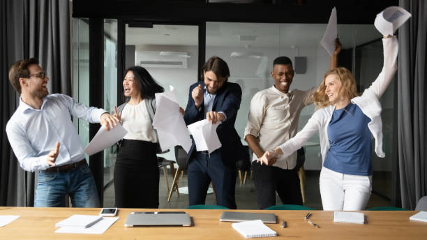 istock Overjoyed multiethnic colleagues have fun celebrating in office 1265084588