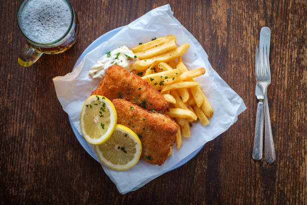 Beer Fish and Chips Authentic traditional British cuisine fish and chips served with an ice cold beer haddock stock pictures, royalty-free photos & images