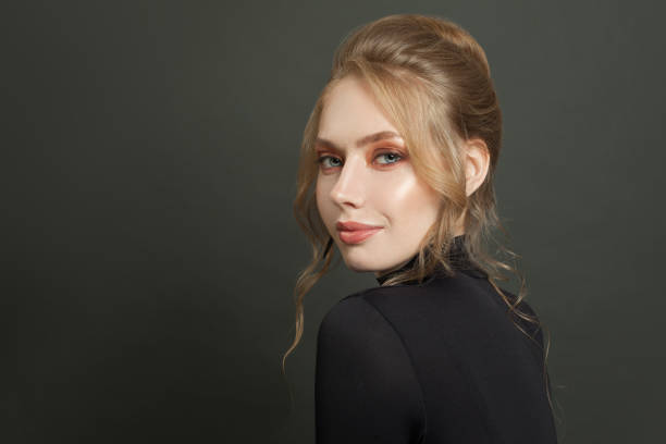 istock Beautiful womanin black turtleneck smiling on black 1265084820