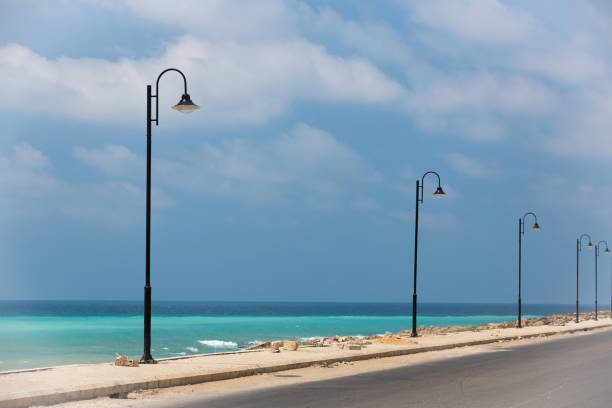 The road along the turquoise sea. Lebanese Mediterranean coastline. Street lights on the waterfront in Lebanon. Sea water of amazing color. The coastland between Sidon and Beirut