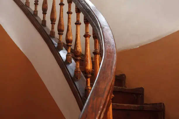 Ancient wooden spiral staircase railing with selective focus
