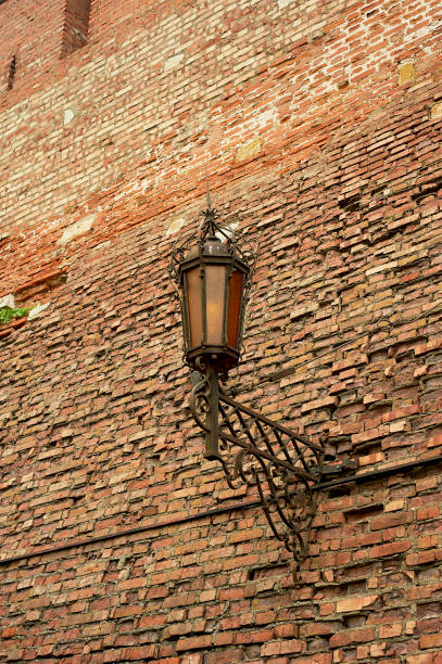 istock An ancient forged lantern on a red brick wall. Ancient fortress, history 1265091224