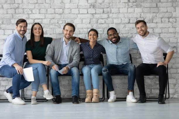 istock Portrait smiling diverse candidates business people hugging, siting in row 1265092965