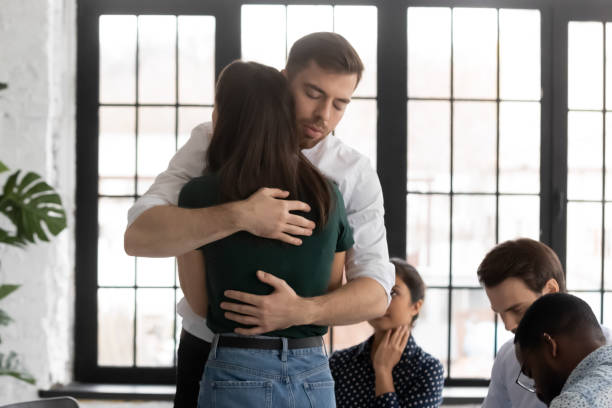 istock Upset man and woman hugging at group therapy session 1265092986