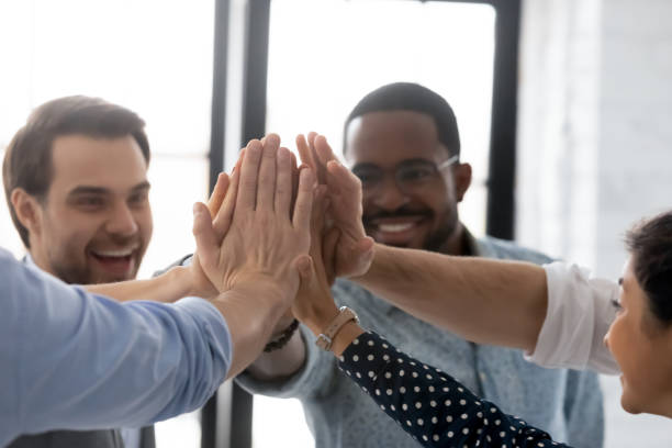 istock Close up diverse business people joining hands, giving high five 1265093315