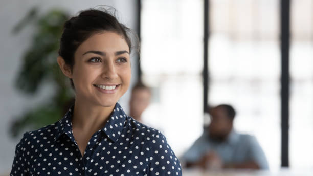 istock Head shot smiling Indian businesswoman dreaming and visualizing 1265093366