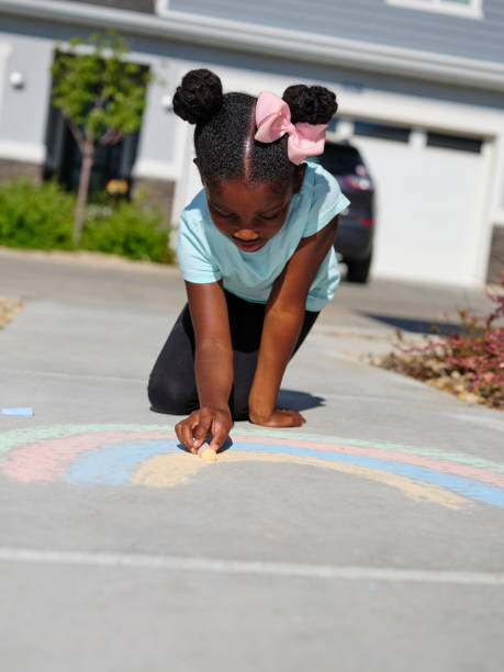 istock Little Girl Drawing with Sidewalk Chalk 1265095954