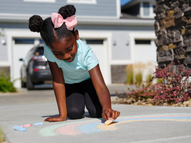 istock Little Girl Drawing with Sidewalk Chalk 1265095968