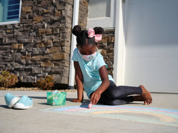 istock Little Girl Drawing with Sidewalk Chalk 1265096000
