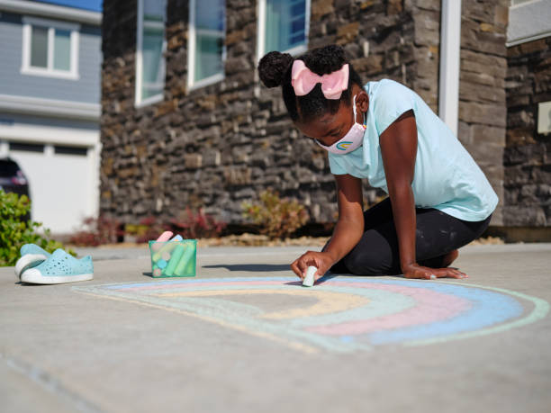 istock Little Girl Drawing with Sidewalk Chalk 1265096014