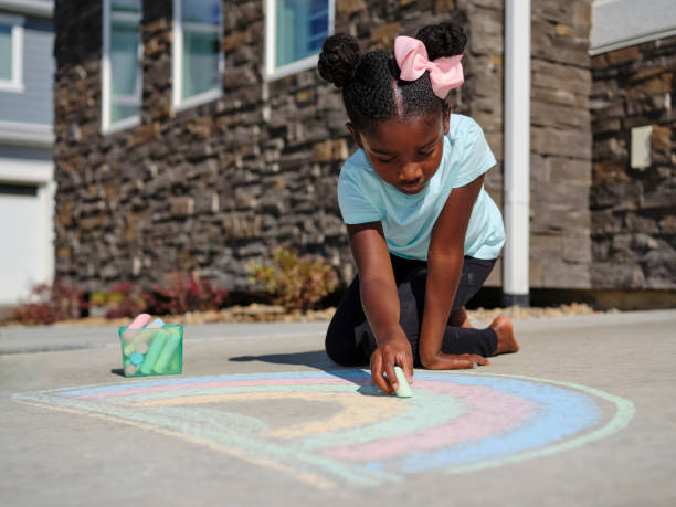 little girl drawing with sidewalk chalk - little girls sidewalk child chalk fotografías e imágenes de stock