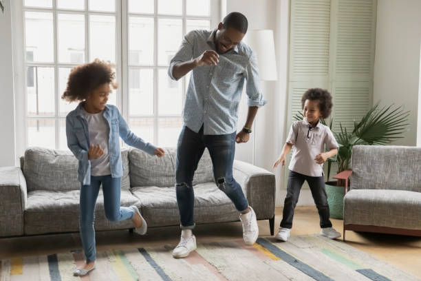 istock Young biracial father dancing with little children 1265096847