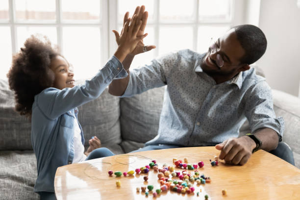 istock Happy ethnic dad and daughter have fun making bracelets 1265096854