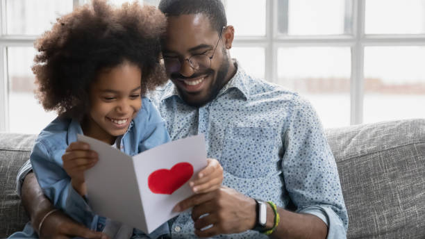istock Smiling young biracial dad and daughter read postcard together 1265096856