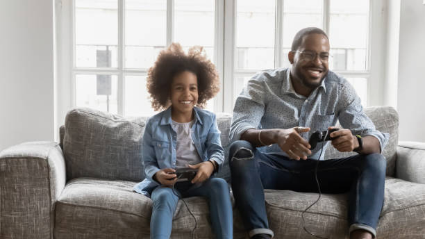 istock Happy ethnic dad and daughter play video games 1265096864