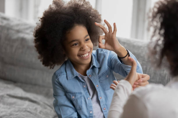 istock Smiling biracial girl talk sign language with mom 1265096881