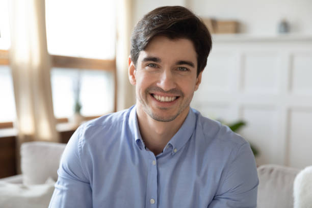 istock Profile picture of young handsome man sitting on sofa. 1265099378