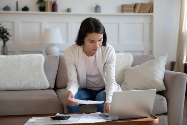 istock Serious young woman accounting taxes with online computer application. 1265099389