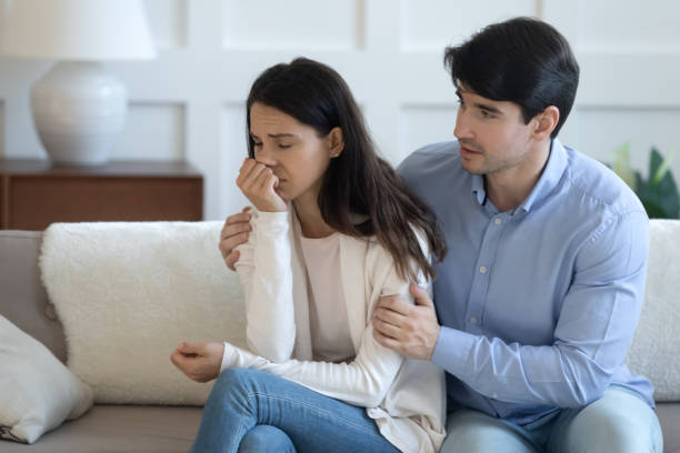 Affectionate caring young man embracing stressed young woman.