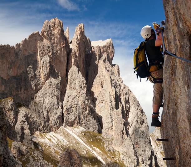 climber on via ferrata in Italy dolomities stock photo