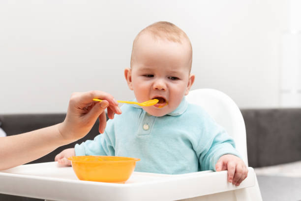 istock Mother Feeding Baby With Spoon 1265103862