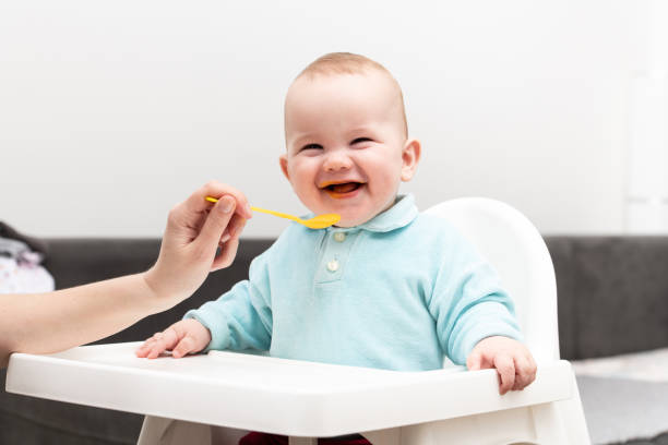 istock Mother Feeding Baby With Spoon 1265103864